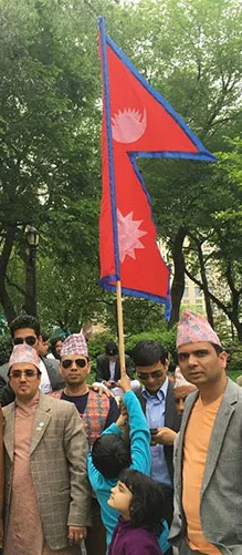 A man holds the flag of Nepal at a parade
