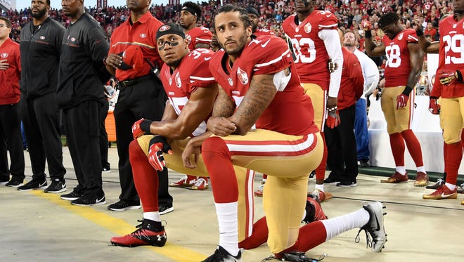 Colin Kapernick kneels during the national anthem