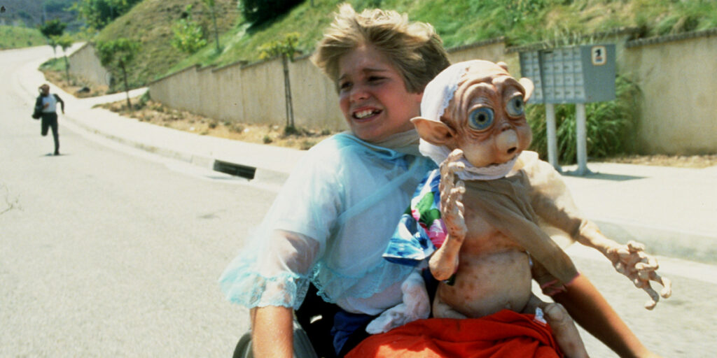 A screenshot from the absolutely terrible film "Mac and Me" (1988) featuring a kid in a wheelchair and an alien something something adventures saving the world?