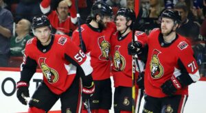 Four hockey players from the Ottawa Senators pro hockey team skate out onto the ice