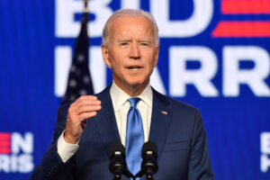 Photo of Joe Biden in front of a flag and campaign sign